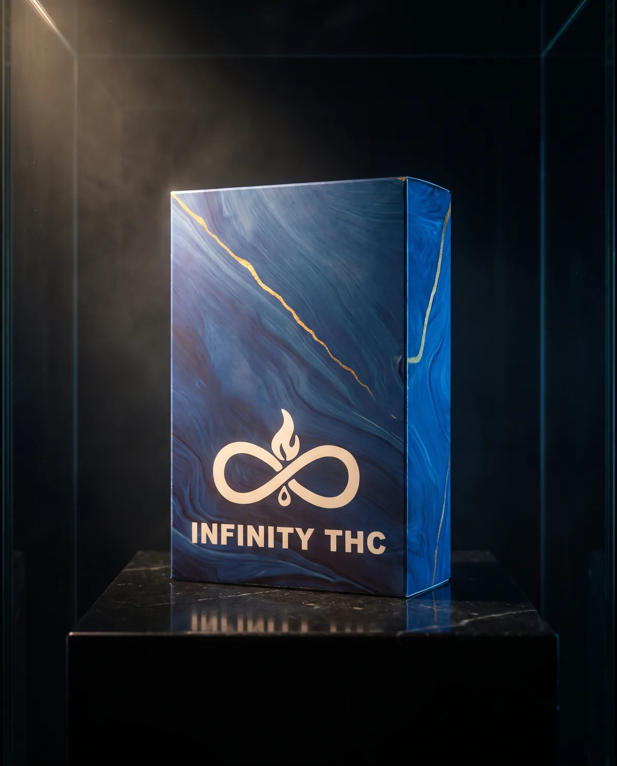 Blue marbled Infinity carton with a thin gold vein and the white flame-and-infinity mark, standing on a black marble plinth in a dark display case