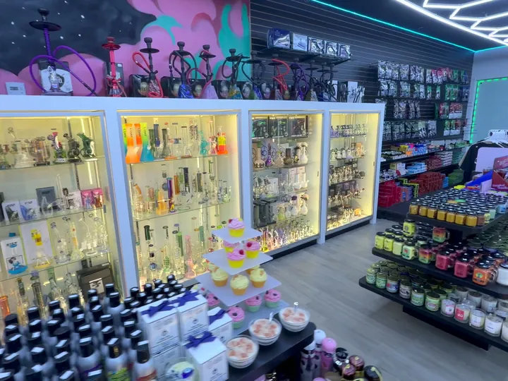 Lit glass cases with water pipes along the left wall, hookahs on top and a candle table in front