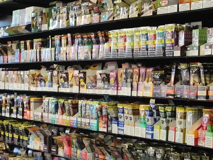 Long wall of cigarillo and wrap packs on black shelves